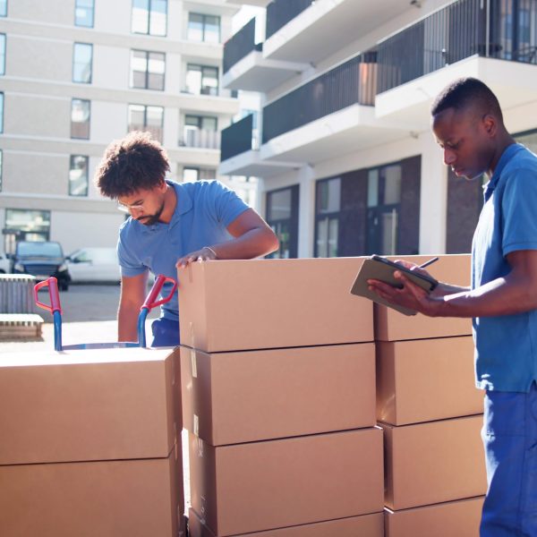 Movers Checking Delivery Boxes Movers Checking Delivery Boxes And Filling Document